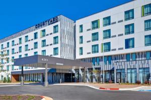 un immeuble de bureaux avec un parking en face de celui-ci dans l'établissement Courtyard by Marriott Bentonville Rogers Promenade, à Rogers