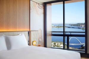 a bedroom with a bed and a large window at The Ritz-Carlton, Perth in Perth