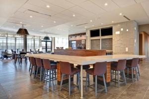 uma grande cozinha com uma grande mesa e cadeiras em Courtyard by Marriott Bentonville Rogers Promenade em Rogers