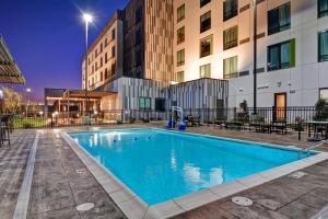 a swimming pool in front of a building at Courtyard by Marriott Bentonville Rogers Promenade in Rogers