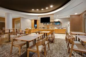 a restaurant with tables and chairs and a bar at SpringHill Suites Erie in Erie