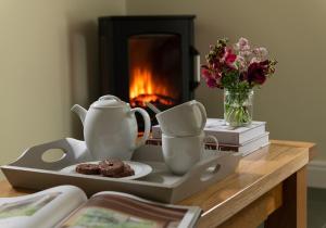 a table with a tea set and a plate with a chocolate dessert at Glandwr Cottage at Hendre Rhys Gethin in Betws-y-coed