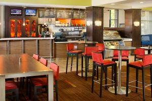a restaurant with tables and red chairs in a kitchen at Courtyard by Marriott Sacramento Midtown in Sacramento