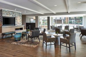 - une cheminée dans le hall de l'hôtel avec des tables et des chaises dans l'établissement Residence Inn by Marriott Cleveland University Circle/Medical Center, à Cleveland