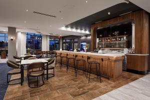 a restaurant with a bar with stools at Courtyard by Marriott Richmond Scott's Addition in Richmond