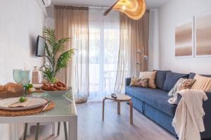 - un salon avec un canapé bleu et une table dans l'établissement Apartamento con terraza cerca de la playa by InsideHome, à Empuriabrava