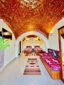 a living room with two couches and a large ceiling at Kendaka Nubian House in Aswan