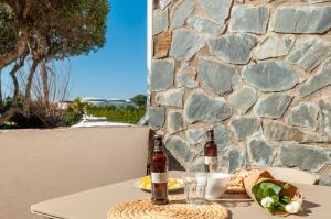 Deux bouteilles de bière assises sur une table avec un mur en pierre dans l'établissement Apartamento con terraza cerca de la playa by InsideHome, à Empuriabrava
