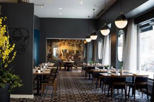 un restaurante con mesas y sillas y un mural en la pared en Hotel Metro, Autograph Collection, en Milwaukee