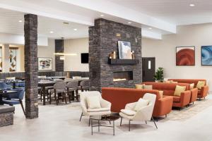 a lobby of a restaurant with chairs and a fireplace at Delta Hotels by Marriott Grande Prairie Airport in Grande Prairie
