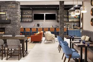 a restaurant with tables and chairs and a bar at Delta Hotels by Marriott Grande Prairie Airport in Grande Prairie