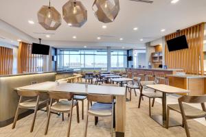 um restaurante com mesas, cadeiras e televisões em SpringHill Suites by Marriott Dallas Mansfield em Mansfield