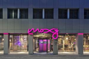 een roze neonbord aan de voorzijde van een gebouw bij Moxy Bucharest Old Town in Boekarest