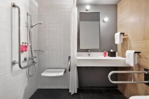 a bathroom with a sink and a shower with a mirror at Moxy Bucharest Old Town in Bucharest +46 photos