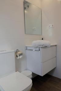 uma casa de banho branca com um WC e um espelho. em Sea front Apartment in La Cala de Mijas em La Cala de Mijas
