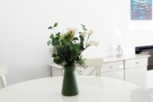 um vaso verde com flores sobre uma mesa em Sea front Apartment in La Cala de Mijas em La Cala de Mijas