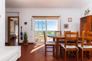 a living room with a table and chairs with a view at Beach Front View Armacao de Pera Flat in Armação de Pêra