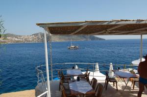 a group of tables and chairs on a boat in the water at Caretta Hotel in Kalkan