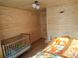 a bedroom with a crib in a log cabin at Przy Łemkowskiej Drodze in Krynica Zdrój