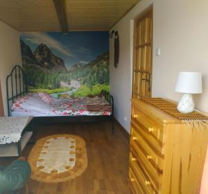 クリニツァ・ズドルイにあるPrzy Łemkowskiej Drodzeのベッドルーム1室(ベッド1台付)が備わります。壁には絵画が飾られています。