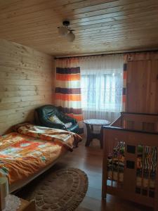um quarto com uma cama e uma janela num chalé de madeira em Przy Łemkowskiej Drodze em Krynica-Zdrój