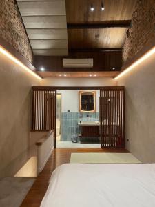 1 dormitorio con cama y vistas a un baño en 灣島 wandao, en Tainan