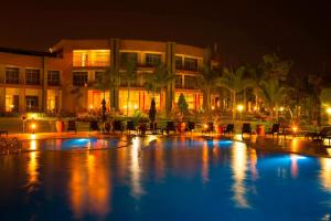 a large swimming pool in front of a building at night at Protea Hotel by Marriott Entebbe in Entebbe
