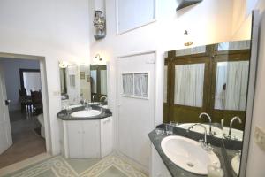 a bathroom with two sinks and two mirrors at Masseria Spina Resort in Monopoli