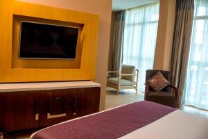 a hotel room with a bed and a flat screen tv at Protea Hotel by Marriott Entebbe in Entebbe