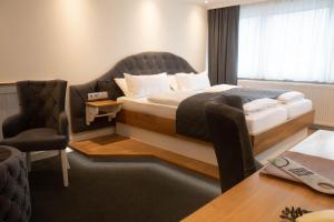 a hotel room with a bed and a chair and a table at Hotel Stadtkrug in Weiden