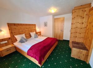 um quarto com uma cama grande e uma cabeceira em madeira em Appartements Luttinger em Biberwier