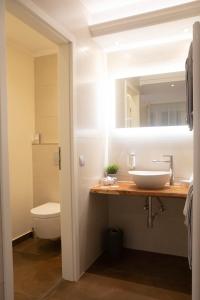 Hotel Stadtkrug في فايدن: حمام مع حوض ومرحاض