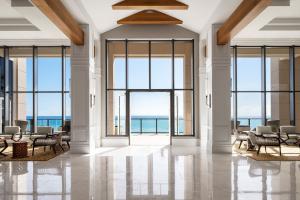 a lobby with large windows and a view of the ocean at The St. Regis Bermuda Resort in Saint George
