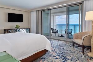 a bedroom with a bed and a view of the ocean at The St. Regis Bermuda Resort in Saint George