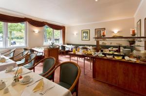 a restaurant with tables and chairs and a buffet at Hotel Victoria in Bad Kreuznach