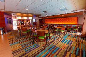 a dining room with tables and chairs on a rug at Fairfield Inn & Suites by Marriott Atlanta Woodstock in Woodstock