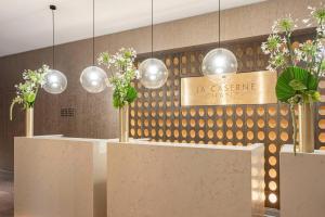 a lobby with tables with flowers and lights at La Caserne Chanzy Hotel & Spa, Autograph Collection in Reims