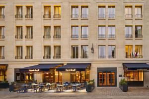 a building with tables and chairs in front of it at La Caserne Chanzy Hotel & Spa, Autograph Collection in Reims