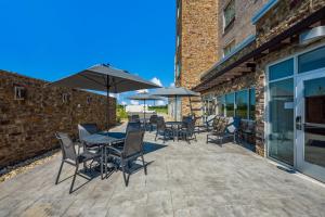 a patio with tables and chairs and umbrellas at Fairfield by Marriott Inn & Suites Columbus Canal Winchester in Canal Winchester