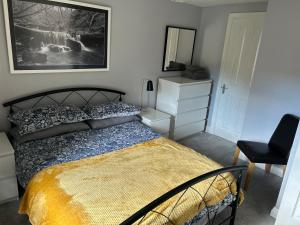 1 dormitorio con cama, escritorio y silla en Mews Cottage en Appleby