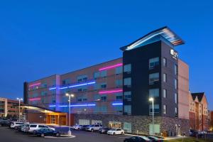 a building with cars parked in a parking lot at Aloft Cincinnati West Chester in West Chester
