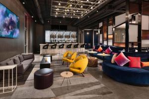 a lobby with couches and chairs and tables at Aloft Cincinnati West Chester in West Chester