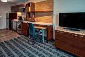 a kitchen with a desk and a tv and a kitchen with a table at TownePlace Suites by Marriott Hot Springs in Hot Springs