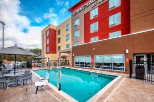 a pool in front of a hotel with a table and chairs at TownePlace Suites by Marriott Hot Springs in Hot Springs