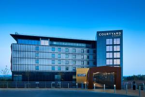 a building with a court yard sign on top of it at Courtyard by Marriott Exeter Sandy Park in Exeter