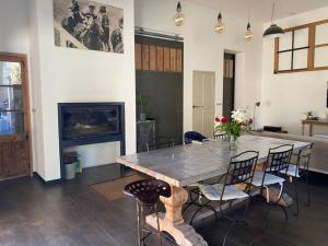 a dining room with a table and chairs and a fireplace at Maison 3 chambres cour/bassin in Pernes-les-Fontaines