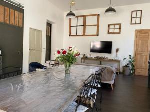 una sala de estar con una mesa con un jarrón de flores en Maison 3 chambres cour/bassin, en Pernes-les-Fontaines