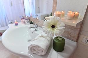 a bathroom with a white flower in a vase on a sink at IzzHome Njoy in Pula +85 photos