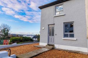 una casa bianca con una porta su un cortile sporco di St. Edwards Hill a Sligo