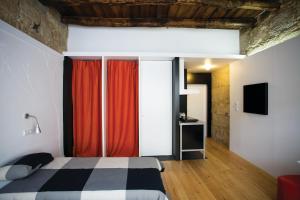 1 dormitorio con 1 cama con cortinas rojas en Belomonte 20 Apartments Porto World Heritage, en Oporto